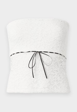 Top sem alças em renda branca com um padrão floral e um laço de fita preta na cintura, apresentando um acabamento texturizado.