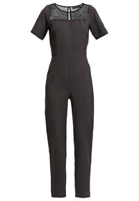 Svart jumpsuit med korta ärmar, spetsinfällning vid axlarna, figurnära silhuett och rak bendesign. Har en nyckelhållsringning och sidofickor.