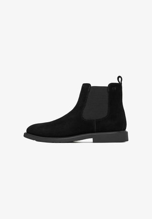 Schwarzer Chelsea-Stiefel aus Wildleder mit elastischem Seitenteil, Zuglasche hinten und niedriger Gummisohle.