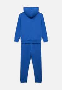 Σετ μπλε φούτερ με κουκούλα και αντίστοιχο παντελόνι φόρμας. Κατασκευασμένο από μαλακό ύφασμα, διαθέτει κουκούλα, μακριά μανίκια και ριμπ μανσέτες στα μανίκια και το παντελόνι.