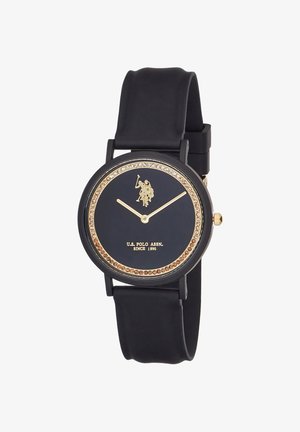 Montre-bracelet noire avec aiguilles en or, logo joueur de polo en or, lunette ornée de cristaux et texte « U.S. Polo Assn. Since 1890 » sur le cadran.