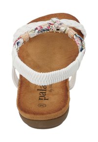 Witte sandaal met gevlochten stoffen bandjes, bloemaccenten, zachte bruine binnenzool en gladde zool. Voorzien van metalen hardware details.