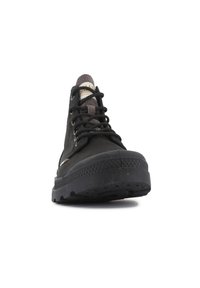 Sneaker alto nero con tomaia in canvas, suola in gomma e lacci neri. Presenta una linguetta testurizzata e un branding minimale sul lato.