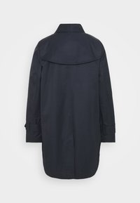 Abrigo largo de un navy oscuro con detalle en la parte posterior, corte recto y puños con tira ajustable, mostrado desde la parte de atrás sobre un fondo gris claro liso.