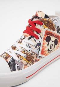 Baskets montantes avec motif Mickey Mouse style bande dessinée, lacets rouges et blancs, semelle en caoutchouc blanche et une bande rouge en détail.