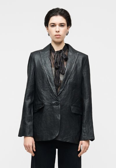 Blazer de cuero negro con un ajuste estructurado, solapas tipo chal, cierre de un solo botón y dos bolsillos frontales. Superficie texturizada con arrugas.