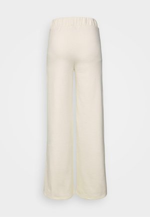 Grietos, plačių kojų kelnės, pagamintos iš minkštos medžiagos; turi elastinę juostą ir lygų paviršių; matomas siuvimas palei apatinius kraštus.