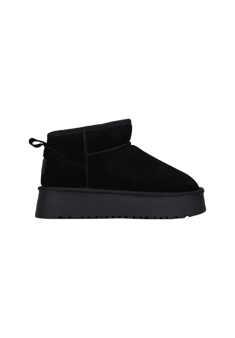 Botines de ante negro con punta redondeada, diseño bajo y suela de goma antideslizante. Cuenta con una lengüeta trasera para facilitar su puesta.