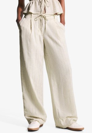 Pantalons large à rayures crème, légers, avec une taille élastique et un cordon de serrage, dotés de poches latérales et d'une texture douce.