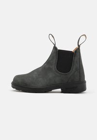 Botín Chelsea de cuero negro con paneles laterales elásticos, lengüetas para facilitar el calzado y una suela de goma texturizada para un mejor agarre. Acabado suave y diseño duradero.