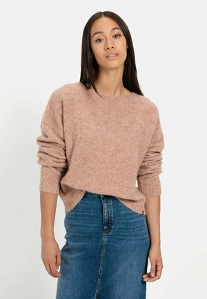 Light pink knitted sweater with a relaxed fit and rolled sleeves, paired with a high-waisted blue denim skirt. Soft texture, minimal detail.