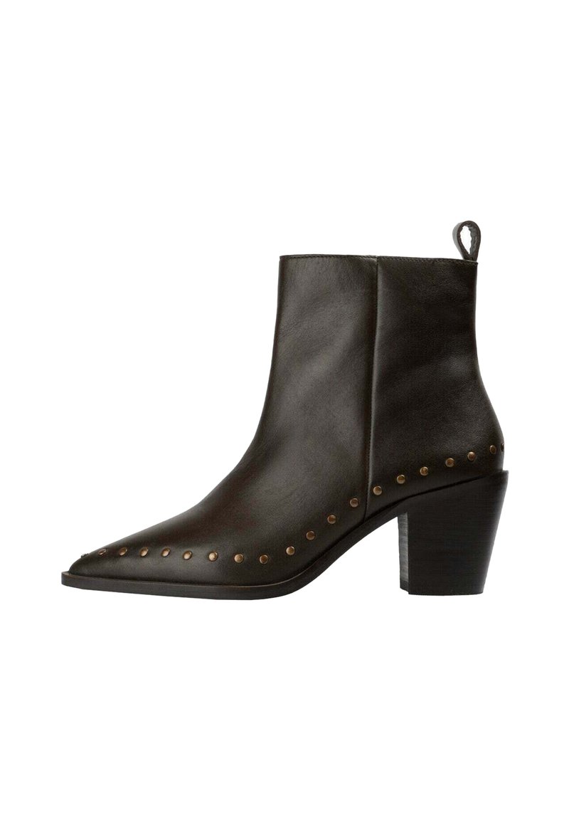 Bota de cuero negro hasta el tobillo con puntera afilada, tacón bajo tipo block, tirador lateral y tachuelas de latón decorativas a lo largo del borde de la suela.