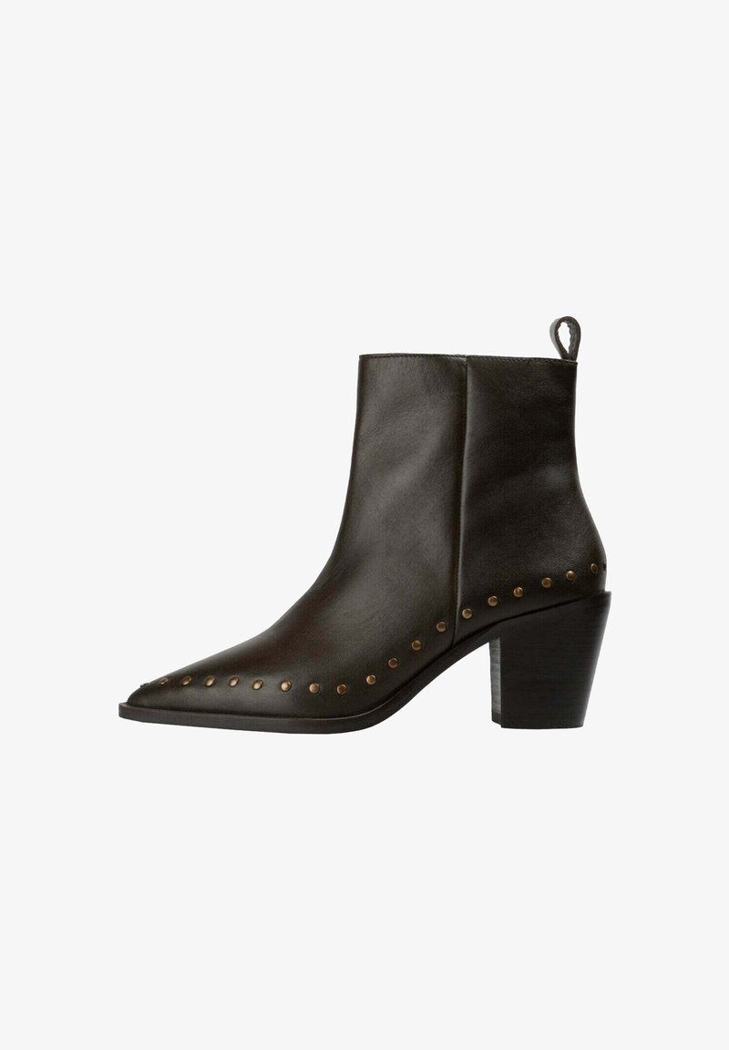 Bota de cuero negro hasta el tobillo con puntera afilada, tacón bajo tipo block, tirador lateral y tachuelas de latón decorativas a lo largo del borde de la suela.