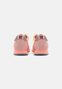 Hardloopschoenen in oranje en roze tinten, met een combinatie van suede en textielmaterialen, een gevoerde zool en contrasterende grijze accenten.