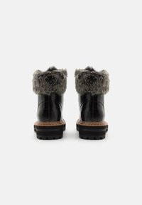 Botas de tobillo negras con relieve de cocodrilo y un puño de piel sintética gris, suela gruesa negra con taco y detalles de costura en color marrón.