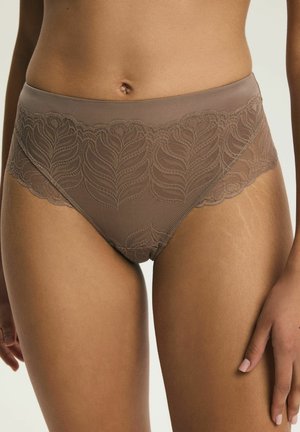 Brązowa wysokiej talii koronkowa bielizna z wzorami liści noszona przez osobę, pokazująca środkową część ciała i górne części ud, z widoczną jedną ręką.