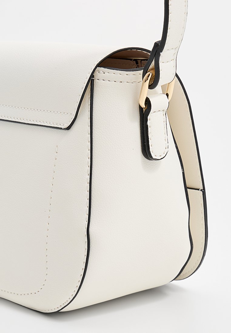 Sac en cuir blanc avec des bordures noires, présentant une forme structurée, une fermeture à rabat magnétique et des accents en métal doré.
