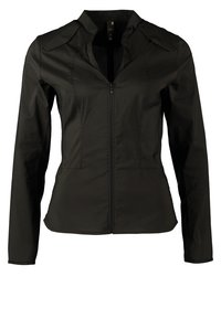 Veste noire ajustée à manches longues, fermeture éclair frontale et bretelles boutonnées aux épaules.