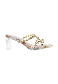 Sandale à talons hauts transparente avec une sangle transparente, des accents carrés dorés et une semelle à motifs. Le talon est rectangulaire et transparent.