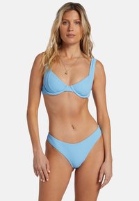 Ljusblå ribbad bikiniuppsättning med en strukturerad bralette med breda axelband och matchande högmidjade underdelar. Texturerad duk.