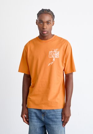 Orange cotton t-shirt with short sleeves, featuring a white graphic of a basketball player and hoop on the left chest area.