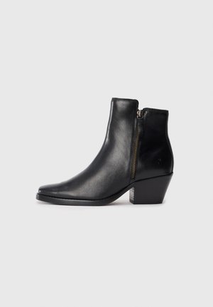 Black leather ankle boot with a pointed toe, side zipper, and a chunky heel. Smooth texture and minimalistic design.