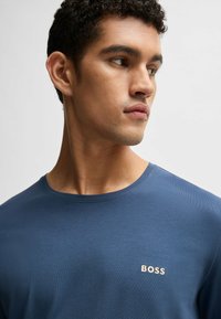 Mörkblå t-shirt i mjukt material, med rund halsringning och en liten "BOSS"-logga i ljusbeige på vänster bröst.