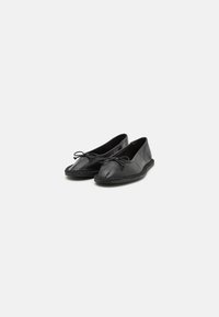 Sorte lær ballet flats med rund tå, med en snører detalj og et vevd mønster langs sålen.