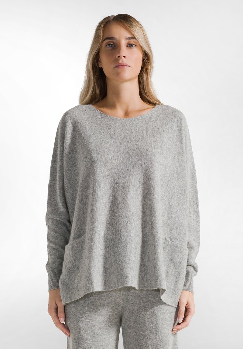 Hellgrauer, übergroßer Strickpullover mit Rundhalsausschnitt, überschnittenen Schultern und zwei Fronttaschen. Weicher Stoff und lockere Passform.