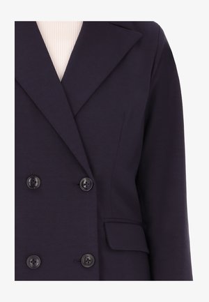Blazer blu navy doppiopetto con revers a punta, due bottoni neri e tasca frontale; realizzato in tessuto morbido con una leggera lucentezza.