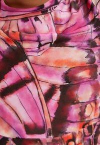 Kolorowa tkanina z abstrakcyjnym wzorem w odcieniach różu, fioletu i pomarańczy. Gładka tekstura z wyraźnymi czarnymi konturami i miękkim układaniem.