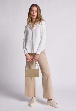 Witte button-up blouse, beige wijde broek, lichte sneakers en een kleine beige handtas. Gladde stof met minimale details.
