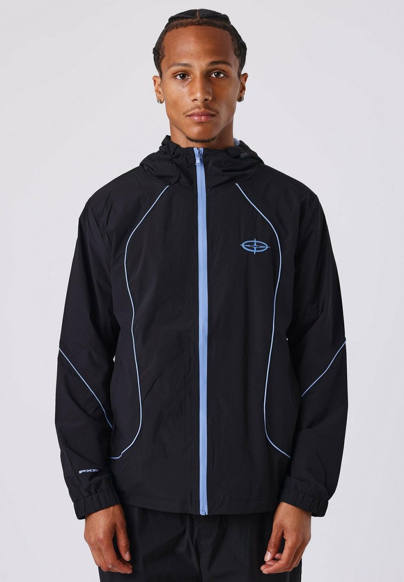 Chaqueta negra con acentos en azul claro, presenta un cierre frontal completo, capucha y puños elásticos. Está hecha de un tejido ligero con un diseño deportivo.