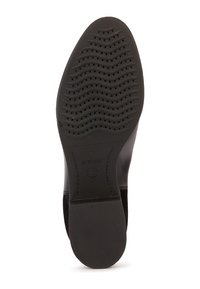 Semelle de chaussure noire avec des motifs ondulés et des perforations, portant la marque "GEOX", dotée d'un talon bas et d'une surface lisse au niveau du talon.
