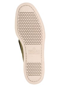 Suela de un zapato Sebago Docksides con una suela de goma beige que presenta surcos ondulados y el nombre de la marca en relieve en el centro.