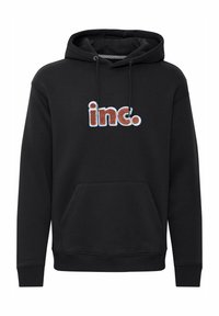 Sudadera negra con bolsillo tipo canguro, con un logo "inc." multicolor y peludo en la parte frontal. Tejido texturizado y capucha con cordón ajustable.