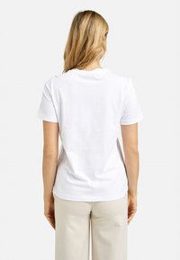 White cotton t-shirt with a crew neckline and short sleeves, featuring a smooth texture and a standard fit, viewed from the back.