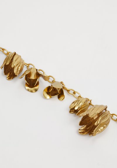 Arany színű lánc karkötő, amely texturált, virágformájú linkekből áll, fényes felülettel és nyitott dizájnnal, ami vizuális mélységet és részletességet biztosít.