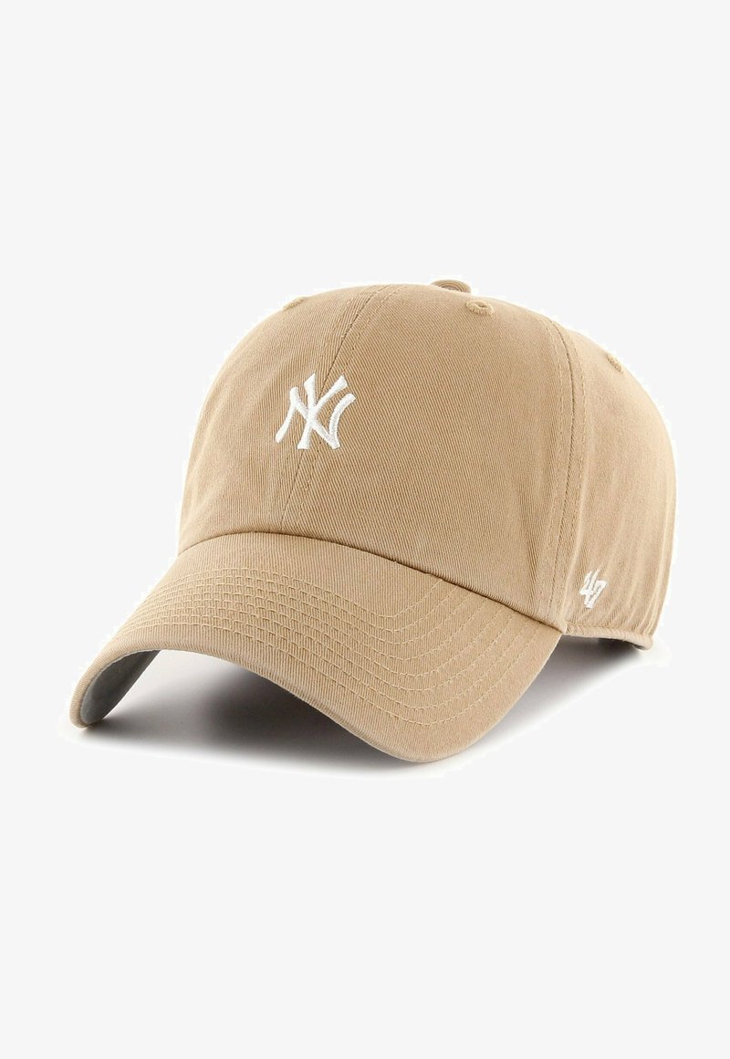 Boné de beisebol bege feito de algodão, apresentando um logótipo bordado em branco dos New York Yankees na frente e um logótipo de destaque na lateral.
