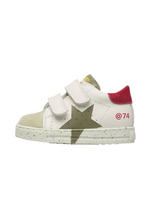 Scarpa da ginnastica bianca per bambini con stella verde, toppa rossa sul tallone, punta beige, due strisce bianche in velcro e numero 74 rosso sul lato.
