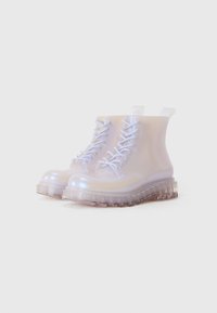 Transparent ankle boots with a glossy finish, white laces, a chunky clear sole, and pull tabs for easy wear. Smooth texture throughout.