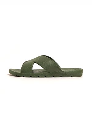 Sandalias verdes de diapositivas hechas de material sintético texturizado, con tiras cruzadas y una suela plana con un borde ligeramente elevado.