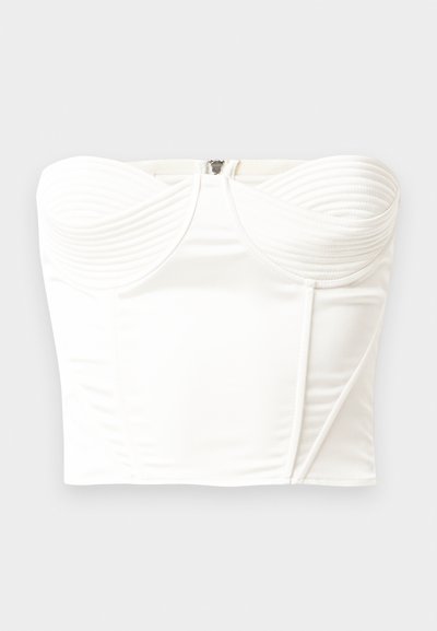 Top branco sem alças com detalhes em canelado na área do busto, acabamento em cetim suave, forma estruturada e um fecho nas costas invisível.