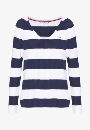 Pull en tricot à manches longues avec rayures horizontales bleu marine et blanches, col en V, et petit logo brodé sur la poitrine.