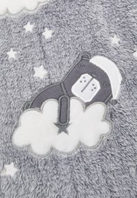 Gray fluffy blanket featuring an embroidered bear wearing a nightcap, surrounded by white clouds and stars, with soft texture and detailed stitching.
