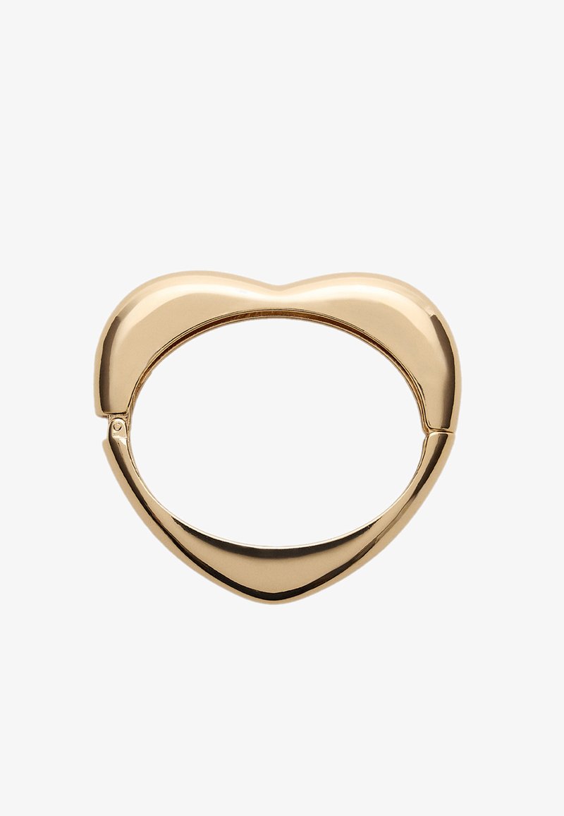 Zlatý prsteň v tvare srdca so hladkým, lesklým povrchom a prázdnym stredom. Obsahuje jedinečný dizajn spony pre bezpečné uzavretie.