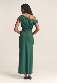 Grünes Satin-Abendkleid mit asymmetrischem schulterfreier Gestaltung, tailliertem Oberteil und langem fließendem Rock, vollendet mit einer glatten Textur.
