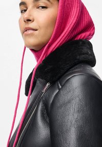 Jachetă din piele neagră cu guler din blană neagră, asortată cu un glugă roz cu dungi. Prezintă fermoar argintiu și o vedere din profil lateral.