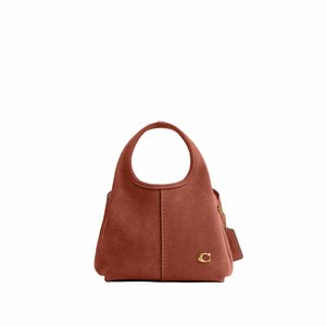 Malá semišová kabelka rezavé barvy s kulatou rukojetí, středovým švem, zlatým logem a připevněnou koženou visačkou na bílém pozadí.