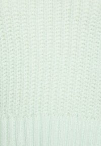 Hellgrüner Strickpullover mit einem strukturierten Muster, ausgestattet mit einem gerippten Saum und einem weichen, flauschigen Material.